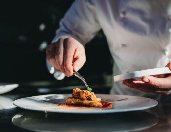 close-up of chef carefully plating elegant meal