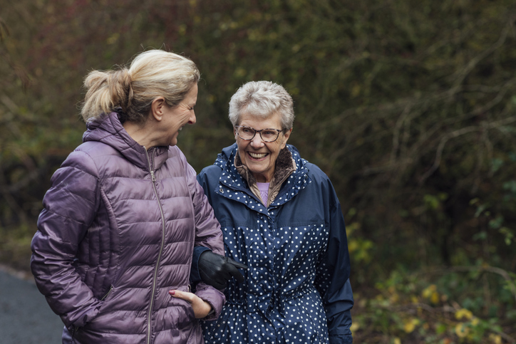 Senior mother happily taking an outdoor stroll with her adult daughter.