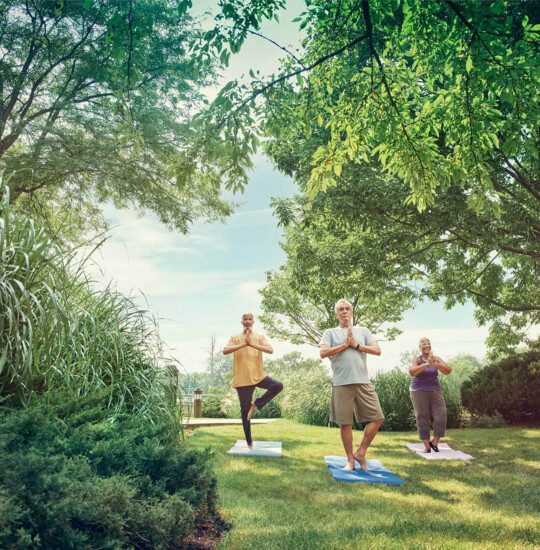 Three men doing yoga outside